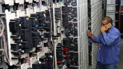 Uno de los empleados de Hondutel en el centro de operaciones probando una línea de telefonía fija.