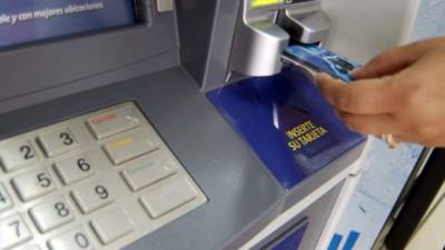 Un usuario financiero inserta su tarjeta de débito en un cajero automático.