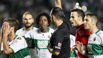 Jugadores del Elche reclaman a Muñiz Fernández tras pitar penal a favor del Madrid.