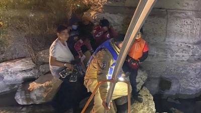 Los rescatados son dos mujeres adultas, una niña y dos niños menores de edad aferrados a un pilar de piedra que sostiene el puente fronterizo.