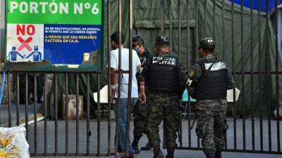 Miembros de la Policía Militar escoltan a un paciente infectado con COVID-19. AFP