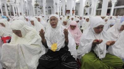 Una mujer recuerda a sus seres queridos durante una misa celebrada en Banda Aceh, primer gran acto en recuerdo del décimo aniversario del tusnami que arrasó el sureste asiático. Foto: AFP.