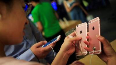 Una cliente revisa un teléfono iPhone en una tienda de Pekín, China.