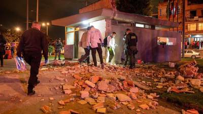 Especialistas en explosivos que inspeccionan el CAI donde explotó un artefacto en Bogotá (Colombia).