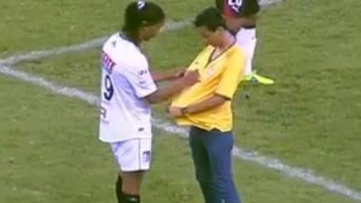 Un aficionado ingresó al Estadio Jalisco y corrió hasta donde estaba la estrella del Querétaro, Ronaldinho, para pedirle que estampe su rúbrica en una camiseta de la selección de Brasil. Foto YouTube