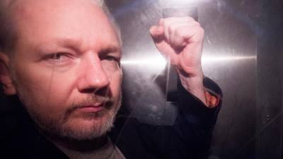 El fundador de Wikileaks, Julian Assange, saluda a los fotógrafos mientras abandona en un vehículo policial, este miércoles, el tribunal de Southwark de Londres (Reino Unido).. EFE/ Neil Hall