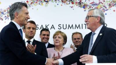Mauricio Macri, Presidente de Argentina, estrecha la mano de Jean-Claude Juncker, presidente de la Comisión Europea, luego de lograr el histórico acuerdo. Foto: AFP