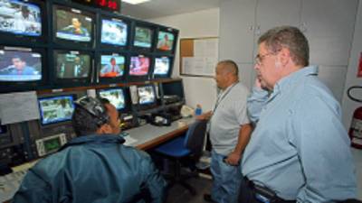 Alberto Federico Ravel (R) chairman of private 'Globovision' broadcast television, opposite to President Hugo Chavez, talks to technicians inside the editing room, 03 October 2003 in Caracas. Venezuela's Telecommunications National Commision (CONATEL) representatives confiscated live transmission equipments based on 'traces that Globovision has been using the radio spectrum without Conatel's authorization', Commission's chairman Alvis Lezam said. AFP PHOTO/Juan BARRETO (Photo credit should read JUAN BARRETO/AFP/Getty Images)