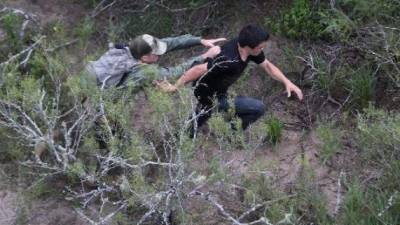 Un agente de las fuerzas de frontera de EEUU intenta agarrar a un inmigrante ilegal en Texas el 9 de setiembre de 2014, cerca de la localidad texana de Falfurrias (GETTY IMAGES/AFP | John Moore)