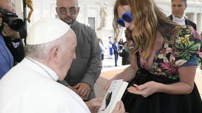 El Papa Francisco recibe un obsequio de una transexual latinoamericana que reciben su bendición cada miércoles por la mañana en la plaza de San Pedro.