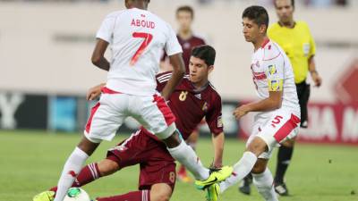 El venezolano Andris Herrera se barre ante la marca de dos jugadores de Túnez.