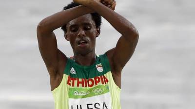 El atleta alzó los brazos y formó una cruz con ellos, un gesto asociado a las protestas contra el Gobierno etíope. FOTO AFP.