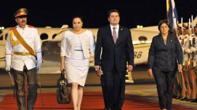 El presidente de Honduras Juan Orlando Hernández (c) camina con su esposa Ana García Carías (2-i) y la ministra de finanzas y precios de Cuba, Lina Pedraza (d), a su llegada hoy, martes 28 de enero de 2014, al aeropuerto internacional José Martí de La Habana (Cuba). Santos visita la isla para participar en la II Cumbre de la Comunidad de Estados Latinoamericanos y Caribeños (Celac). EFE