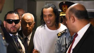 Brazilian retired football player Ronaldinho (C) arrives at Asuncion's Justice Palace to testify about his irregular entry to the country, in Asuncion, on March 6, 2020. - Former Brazilian football star Ronaldinho and his brother have been detained in Paraguay after allegedly using fake passports to enter the South American country, authorities said Wednesday. (Photo by Norberto DUARTE / AFP)