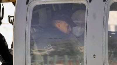 Un integrante de la Guardia Nacional (GN) acompaña el traslado en helicóptero del narcotraficante Rafael 'Caro' Quintero (derecha) al penal del Altiplano.