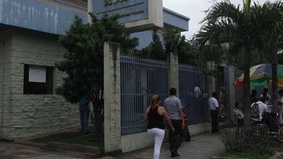 Personas caminan frente a las oficinas del Régimen de Aportaciones Privadas (RAP) en San Pedro Sula.