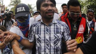 El boxeador filipino y candidato al senado, Manny Pacquiao saluda a la multitud durante un acto de campaña electoral en la ciudad de Bay. Foto EFE/ Francis R. Malasig.