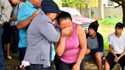 Dos mujeres lloran por la muerte de un familiar, recluso del centro penitenciario de Tela, este sábado en el municipio de Atlantida (Honduras). EFE