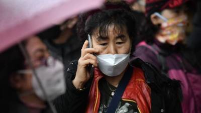 Una mujer habla por su teléfono celular mientras espera en una fila para comprar máscaras faciales en una tienda minorista en la ciudad de Daegu, en el sureste del país, el 25 de febrero de 2020. Corea del Sur reportó 60 casos más de coronavirus COVID-19 el 25 de febrero, el aumento más pequeño durante cuatro días en las actualizaciones matutinas de los Centros para el Control y la Prevención de Enfermedades de Corea. El país ahora tiene 893 casos. / AFP / Jung Yeon-je