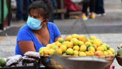 Una comerciante en las calle de Tegucigalpa vende frutas para sobrevivir durante la crisis por el coronavirus. AFP