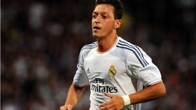 (FILES) In this file photo taken on June 26, 2016, Germany's midfielder Mesut Oezil (R) reacts during the Euro 2016 round of 16 football match between Germany and Slovakia at the Pierre-Mauroy stadium in Villeneuve-d'Ascq near Lille on June 26, 2016.Mesut Ozil's decision to quit playing for the German national football team Die Mannschaft unleashed on July 23, 2018 a racism storm in Germany, but earned the applause of Ankara with a Turkish minister hailing 'a goal against the virus of fascism'. / AFP PHOTO / KENZO TRIBOUILLARD