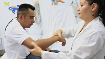 La reumatóloga Gabriela Guzmán examina a Julián Reyes, quien padece la enfermedad.