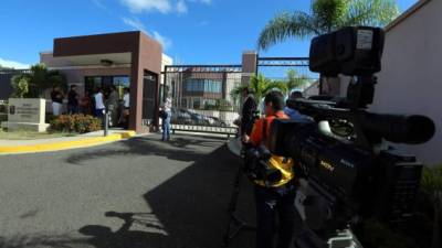 Visitantes esperan frente a la sede del Banco Interamericano de Desarrollo en la ciudad de Tegucigalpa.