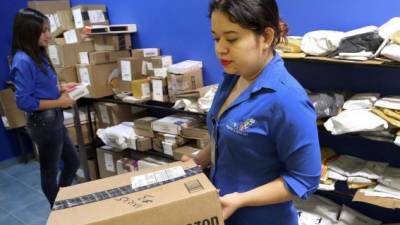 Diana Velásquez y Vivian Valdez, empleadas de GboxMall, revisan cajas que contienen artículos comprados en Amazon. Foto: Yoseph Amaya