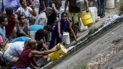 Desesperados por la escasez de agua, alimentos y medicinas, cientos de venezolanos se lanzaron este lunes a recoger agua del contaminado río Guaire debido a la imposibilidad de recibir el vital líquido en sus hogares por causa del apagón que afecta al país desde el pasado jueves.