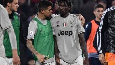 Juventus' Portuguese defender Joao Cancelo (C-L) comforts Juventus' Italian forward Moise Kean at the end of the Italian Serie A football march Cagliari vs Juventus on April 2, 2019 at the Sardignia Arena in Cagliari, after Cagliari's fans threw projectiles at him following his goal. (Photo by Marco BERTORELLO / AFP)