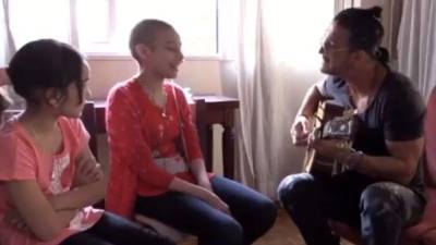 El artista cantando una de sus canciones con la paciente Veronica. Foto captura.