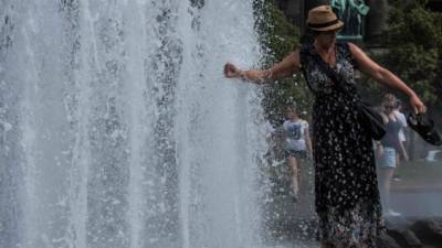 Una mujer se refresca en una fuente de agua de las fuertes temperaturas que imperan en el sur de España./AFP.