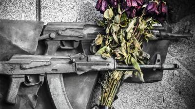 Una vista detallada muestra flores marchitas que adornan rifles de asalto AK-47 esculpidos en el monumento histórico a su inventor, el ruso Mikhail Kalashnikov, en el centro de Moscú .