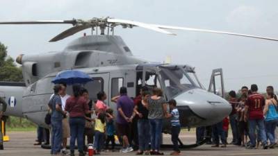 Las personas se acercan a los helicópteros militares para conocer su interior.