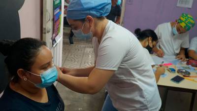 Personal del centro de salud Miguel Paz Barahona aplica una dosis de vacuna contra el covid-19 a una joven.