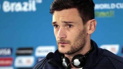 France's goalkeeper Hugo Lloris (C), flanked by France's forward Antoine Griezmann (L) and France's defender Raphael Varane (R), holds the trophy as he celebrates with teammates while they disembark from the plane upon their arrival at the Roissy-Charles de Gaulle airport on the outskirts of Paris, on July 16, 2018 after winning the Russia 2018 World Cup final football match. / AFP PHOTO / Thomas SAMSON