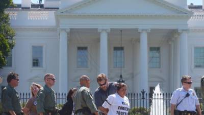 (FILES) Police arrest immigrant rights supporters after they failed to disperse from the front of the White House in this August 28, 2014, file photo, in Washington, DC. The demonstrators called for US President Barack Obama to stop deportations. Obama will wait until after November's midterm elections to reform the US immigration system, in a clear bid to shield lawmakers crucial to the Democratic Party's hopes of clinging on to the US Senate. A White House official said on September 6, 2014, that Obama had taken the decision to hold off on using his presidential powers to remake a system Congress has failed to fix until after congressional polls. AFP PHOTO/Mandel NGAN/FILES