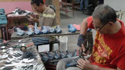 Los negocios han despedido personal para poder seguir operando. En la imagen, un taller de zapatería en San Pedro Sula.