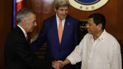 El presidente filipino Rodrigo Duterte saluda al embajador de EUA Philip S. Goldberg bajo la mirada de John Kerry.