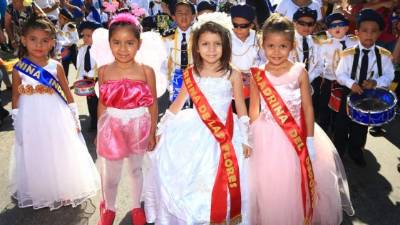 Un grupo de niñas en trajes de gala desfilan en honor a la patria.