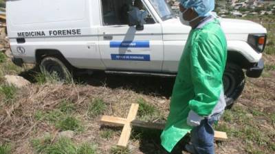 Un integrante de Medicina Forense se presenta a un entierro masivo de cuerpos. Foto de archivo.