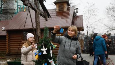 Los ucranianos decoran un árbol de Navidad cerca de la Plaza de la Independencia en Kiev, Ucrania. Ángeles y corazones simbolizan las almas de las personas asesinadas durante el levantamiento de Maidan en 2013-2014 y el conflicto armado entre Rusia y Ucrania que comenzó en febrero de 2022. EFE/EPA/SERGEY DOLZHENKO