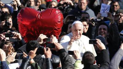 El papa Francisco (c) saluda durante una audiencia celebrada con motivo del día de San Valentín en la Plaza de San Pedro, en Ciudad de Vaticano (Vaticano), donde se reunió con 20.000 parejas de 28 países de todo el mundo, hoy, viernes 14 de febrero de 2014.
