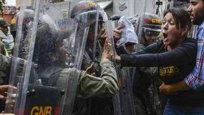 Diputados opositores venezolanos protagonizaron este jueves una refriega con militares frente a la sede del Tribunal Supremo de Justicia (TSJ) en Caracas, adonde acudieron para rechazar una sentencia con la que esa corte asumió sus funciones.