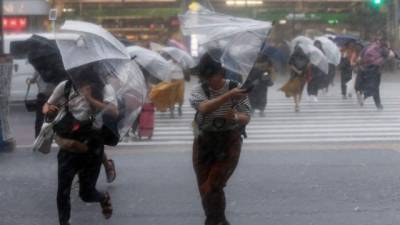 Los transeúntes se protegen de las fuertes lluvias que caen sobre Tokio.