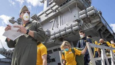 Personal militar a bordo el Portaaviones USS Theodore Roosevelt, en donde murió un marinero contagiado de coronavirus.