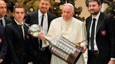 El papa Francisco carga la Copa junto a los jugadores.