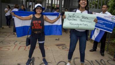 Dos mujeres gritan arengas de apoyo al líder campesino y representante en la mesa de diálogo nacional Medardo Mairena durante un plantón frente a los juzgados de Managua (Nicaragua). EFE