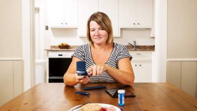 A diabetic woman checking her blood sugar at home.Please browse: