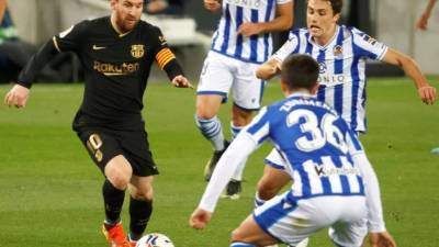 Lionel Messi controla el balón junto a Martín Zubimendi (c) y Ander Guevara, ambos de la Real Sociedad. Foto EFE.